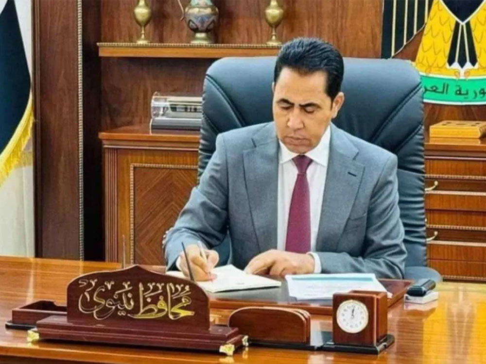 محافظ نينوى عبد القادر الدخيل يجلس خلف مكتبه ويوقع على وثائق رسمية داخل مكتبه