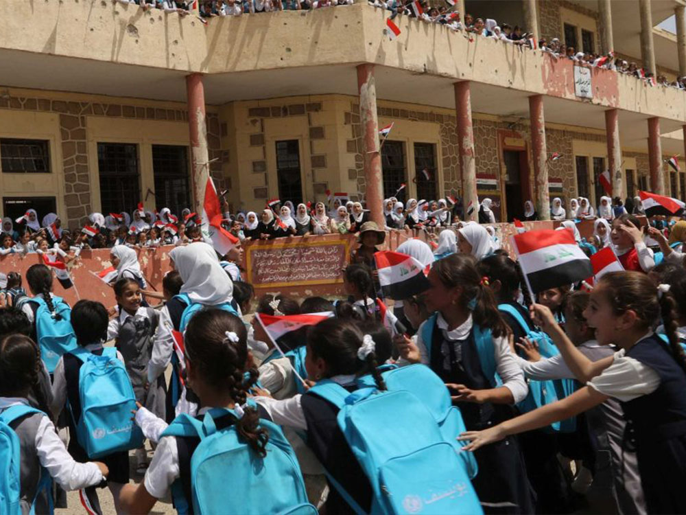 تلاميذ عراقيون يشاركون في فعالية مدرسية داخل إحدى المدارس، في مشهد يعكس واقع البيئة التعليمية في العراق والتحديات المرتبطة بتوفير الأبنية المدرسية.