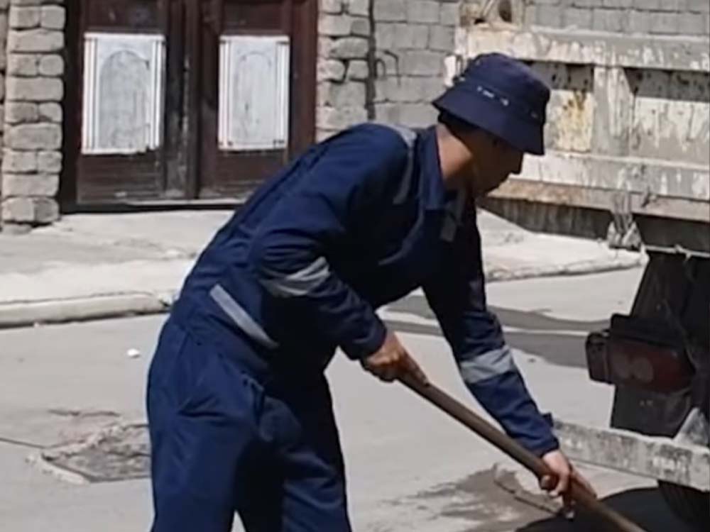أحد عمال مديرية المجاري ينفذ أعمال تنظيف وتسليك شبكة الصرف الصحي في منطقة الأربجية، ضمن حملة خدمية تهدف إلى إزالة الترسبات وتحسين كفاءة تصريف المياه.