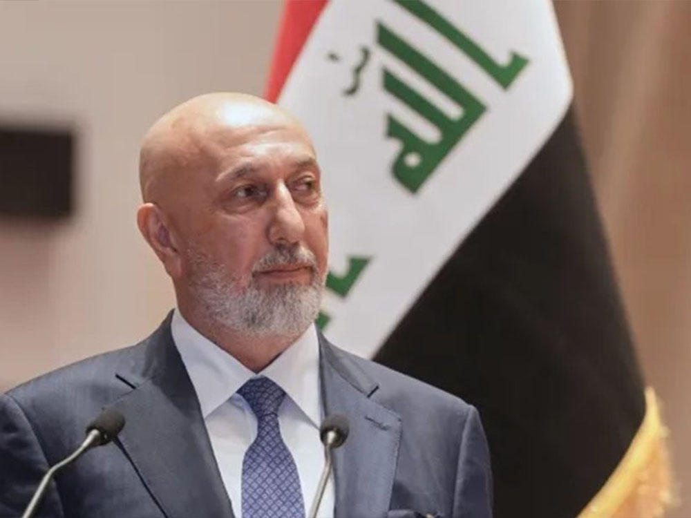 رئيس الجمهورية العراقي يظهر خلال كلمة رسمية، متحدثًا من أمام منصة وبحضور العلم العراقي في الخلفية.