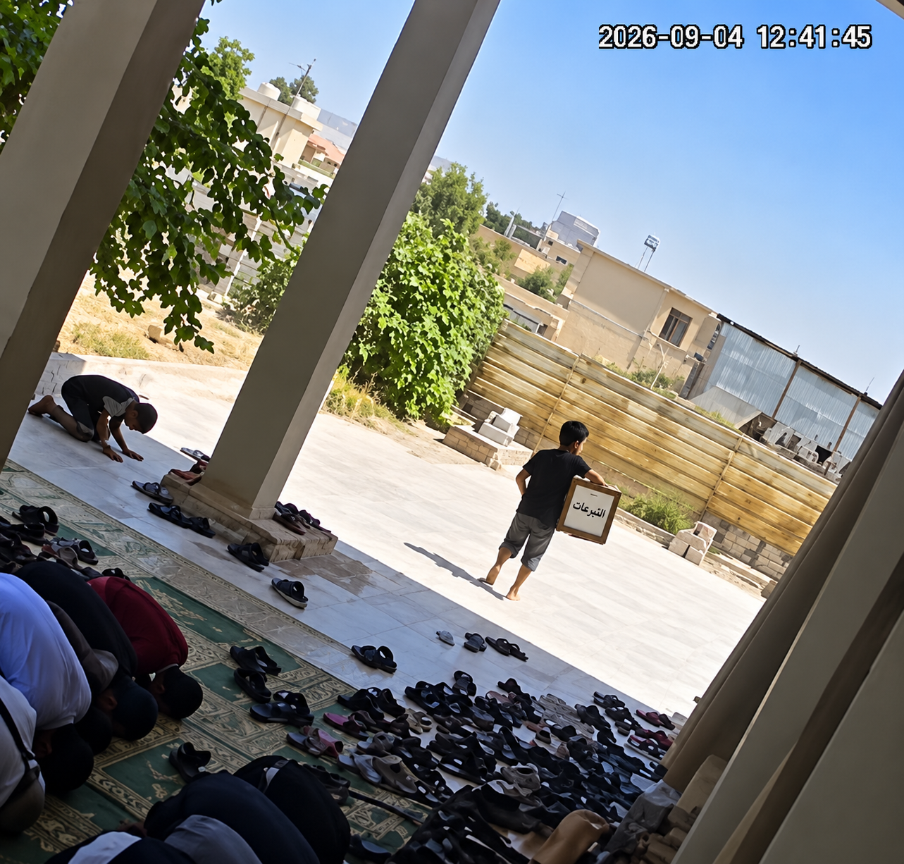 لقطة من كاميرا مراقبة داخل أحد جوامع الموصل تُظهر طفلًا قرب صندوق التبرعات خلال صلاة الجمعة