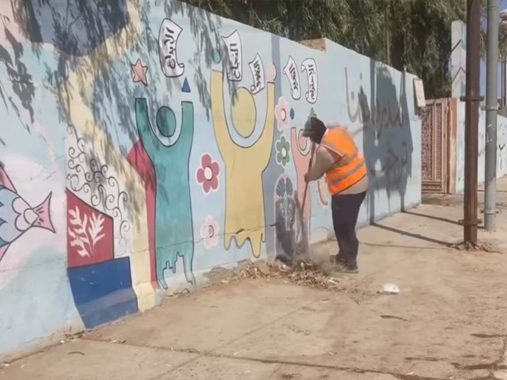 عامل بلدية ينظف محيط إحدى المدارس في الموصل ضمن حملة الاستعداد للعام الدراسي الجديد