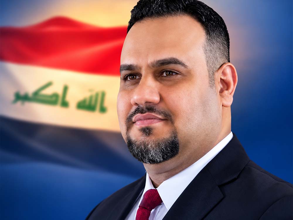 النائب أحمد سالم الساعدي في صورة رسمية أمام العلم العراقي