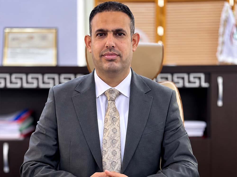 محمد مظهر البياتي المكلف بإدارة مديرية تحقيق هيئة النزاهة في محافظة نينوى، يرتدي بدلة رسمية داخل مكتبه.