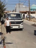 آلية إنشائية تزيل تجاوزاً على أحد الشوارع والأرصفة في مدينة الموصل