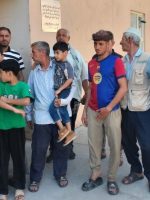 مجموعة من سكان مجمع باب سنجار السكني في الجانب الأيمن من مدينة الموصل، بينهم رجال وأطفال، يقفون أمام إحدى البنايات السكنية خلال وقفة احتجاجية اعتراضًا على قرارات إخلاء الشقق.