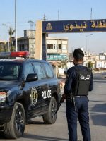 عناصر من الشرطة العراقية يقفون إلى جانب مركبة أمنية عند أحد مداخل محافظة نينوى في مدينة الموصل، ضمن مشهد يرمز إلى الإجراءات الأمنية وتنفيذ الواجبات الرسمية.