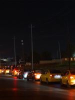 طابور طويل من السيارات يصطف ليلاً على أحد شوارع الموصل بانتظار الوصول إلى محطة لتعبئة الوقود.