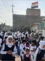 طلاب وطالبات أمام إحدى المدارس العراقية أثناء توجههم إلى الدراسة