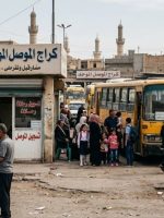 کراج نقل في مدينة الموصل تظهر فيها الحافلات والسيارات والمواطنون، مع لوحات إرشادية وخلفية تضم مباني المدينة ومآذن المساجد.